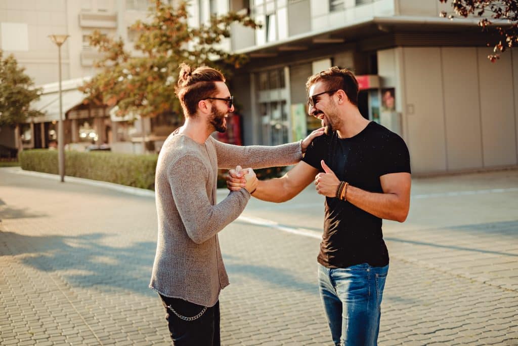 Old friends meet and laughing while shaking hands