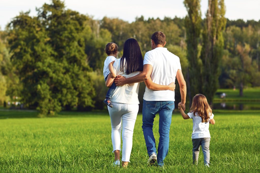 Rear view Happy family with children walking in the park