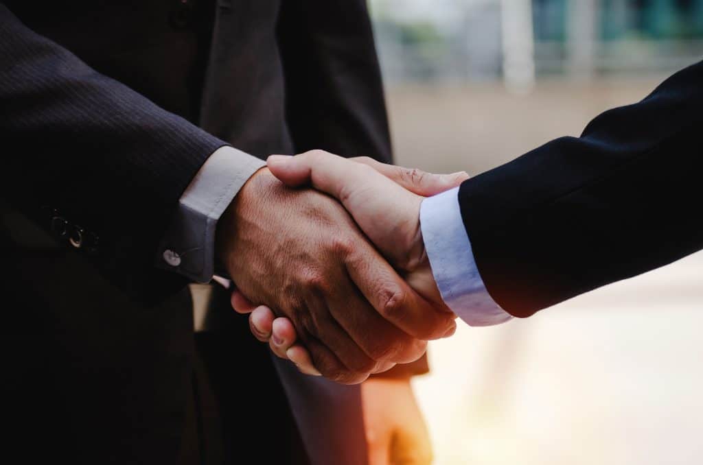 close up of business man in suit shaking hands after finishing u