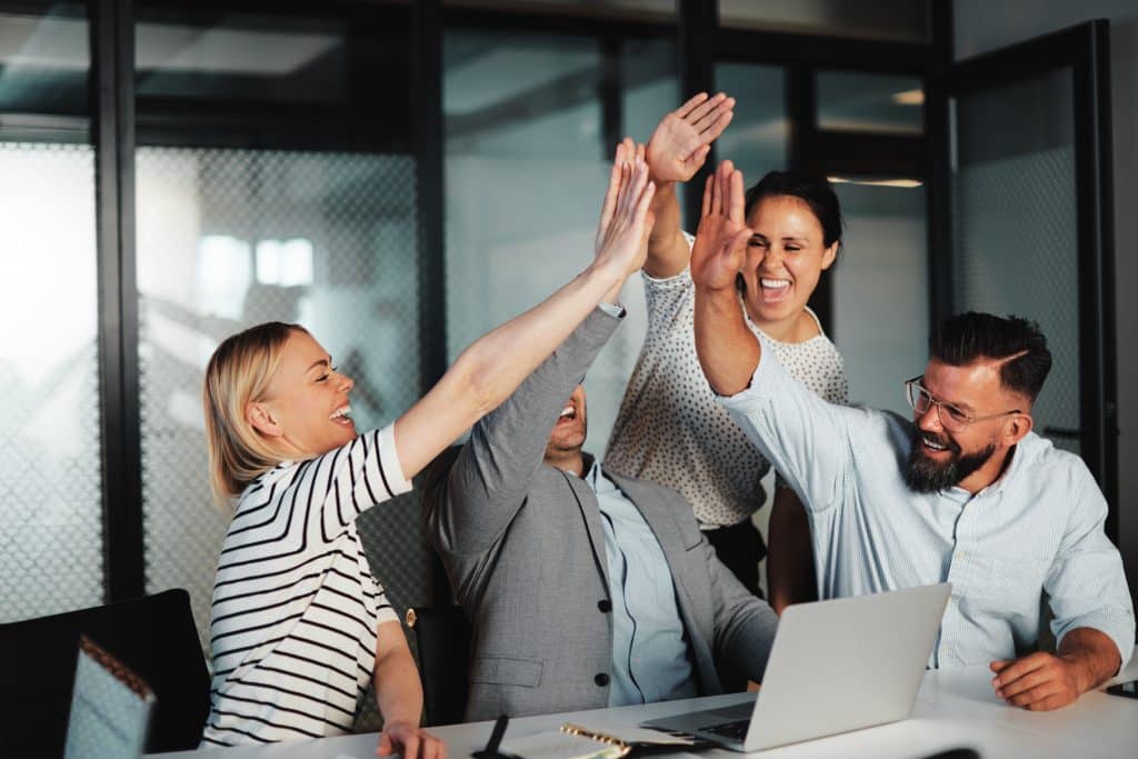 Businesspeople high fiving at work