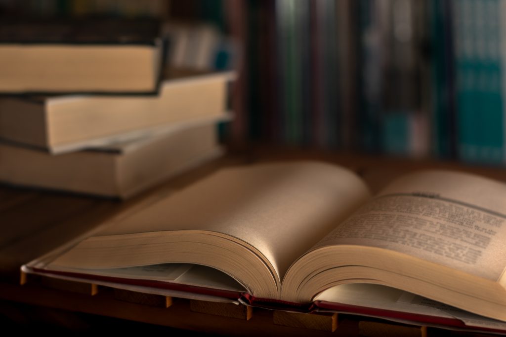 Stack of books on the library. World book day. Knowledge, education and learning concept. Selective focus.